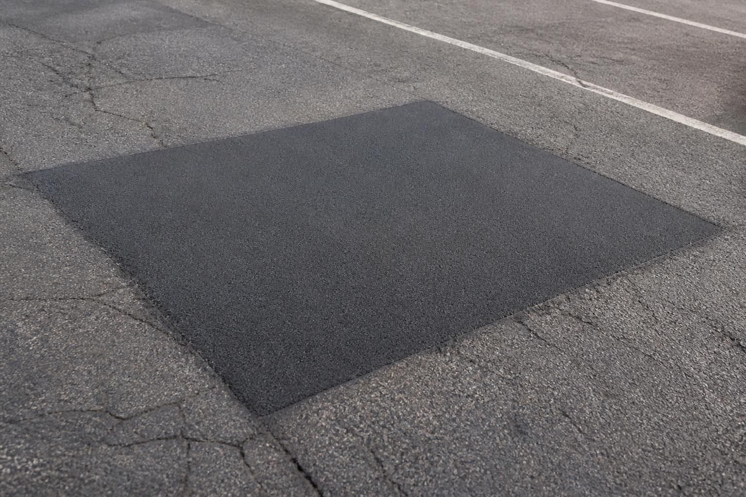 Parking lot repair with smooth patched asphalt transitions